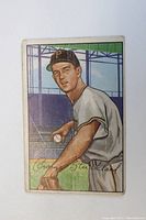 Front of vintage 1952 Bowman baseball card showing George Strickland in Pirates uniform, holding ball, with visible wear and printed signature.