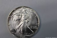 Front side of 1987 Walking Liberty Silver Dollar showing Liberty figure with flowing gown and sunrise.