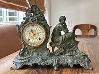 Front view of the entire bronze mantel clock showing ornate case and seated figure