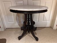 Full front view of the oval marble top pedestal table