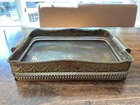 Side view of rectangular castilian brass tray showing pierced edge design and embossed scroll pattern band around sides.