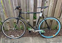 Full side view of the black SE Lager bicycle showing frame, wheels, pedals and brakes.