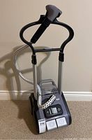 Front view of Rowenta Precision Steamer showing upright frame, hose, handheld steamer head, control panel, and wheels.