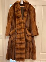 Front view of full-length sable fur coat hung against door