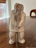 Front view of the carved whalebone figure standing on tabletop
