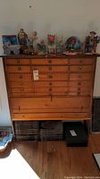 Front view of pine wood multi-drawer cabinet with decorative items on top