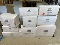 Nine white boxes labeled Heritage Village Collection with various accessory names, some with orange sticker and visible wear on one box.