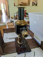 Front angle view of magic lantern projector on wooden base inside opened case