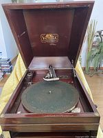 Open cabinet interior showing green felt turntable and metal tonearm