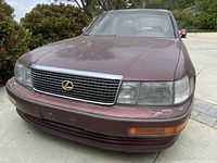 Front view showing grille, headlights and front bumper with faded burgundy paint