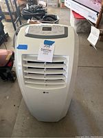 Front view of white LG portable air conditioner with air vent and blue tape label.