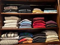 Shelves with neatly folded variety of men’s sweaters in multiple colors and patterns.