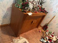 Closed view of wood veneer buffet table with two front doors, walnut finish, decorative items on top