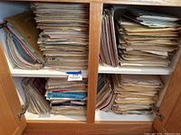 Two lower shelves filled with stacked sheet music folders and loose leaves.