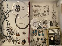Tray overview showing multiple necklaces, bracelets, earrings and charms.