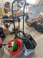 Front angle view showing work dolly, buckets with twine and hose, vacuum in box