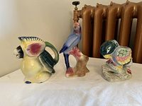 Three ceramic bird figurines displayed on a table under natural light