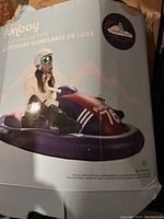 Photo of the original box showing a girl using the inflatable snow sled with winter gear, helmet and goggles. Shows product look and branding.