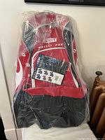 Front view of new red and black Grit Hockey Pod hockey bag wrapped in plastic with white zippers and Grit logo.