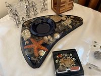 Photo showing a large triangular Lucite piece with embedded sea life including a starfish, shells, and coral, a small square piece with crab and opener, and part of a wire stand.
