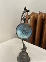 Front view showing compass face of the porthole desk clock with detailed compass rose design under glass.