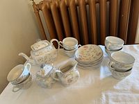Full view of the vintage Johnson Brothers Savoy china set including teapot, sugar bowl, creamer, cups, and saucers on a cloth background.
