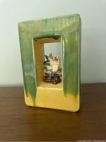 Front angle showing rectangular hollow vase with blue bird figurine inside.