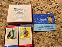 Two sealed packs of playing cards and the original box with Norman Rockwell artwork "The American Way"