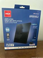 Photo of the front of the packaged RCA amplified indoor flat HDTV antenna multi-directional showing brand, model, and key features.