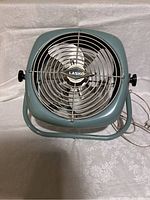 Front view of the vintage Lasko 14-inch enamel table fan showing the metal grille, three metal blades, and logo.