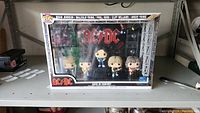Front view of boxed AC/DC In Concert Funko Pop set showing band members and stage backdrop.