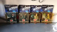 Full view of four boxed Babylon 5 figures in sealed packaging showing front labels and figures inside.