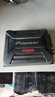Top view of black Pioneer car amplifier showing Pioneer logo and 400W power rating in red.