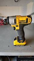 Front side view of DeWalt cordless impact driver drill showing drill chuck and grip.