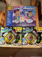 Photo of Crayola Colour Chemistry tie-dye lab set and two Crashlings Meteor Missile Ship toys in original packaging showing front view.