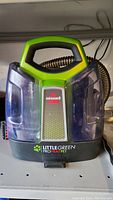 Front view of the Bissell Little Green ProHeat Pet cleaner showing handle, water tank, and branding.