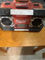 Front view of Milwaukee construction site radio showing speakers, digital display, and scuffed surface.