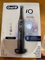 Box front showing Oral-B iO Series 7 in black onyx with product name and included items list