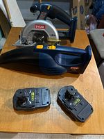 Ryobi circular saw and handheld vacuum with two 18V One+ batteries on wooden table