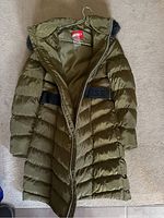Full view of long olive green puffer jacket with hood and black belt.