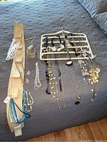 Photo showing multiple necklaces with beads, white and black accents, displayed on jewelry holders and fabric surface.