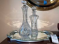 Two crystal decanters on mirrored serving tray
