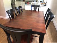 Six Canadel dining chairs arranged around a wooden table in a kitchen setting, showing overall set and color contrast.