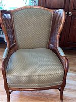 Front view of chair showing wood frame, cane sides, upholstered seat and back