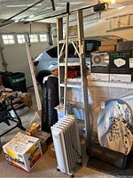 Step ladder, electric heater, snow rake, heat tool and other items in a garage setting