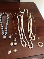 Overview of all pearl jewelry items arranged on table