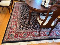 Overall view of rug under dining table showing full design and condition