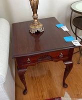 Full view of the Pennsylvania House wooden side table with brass lamp on top. Shows the overall design, wood finish, and condition of the table.