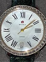 Front view of watch showing diamond-set bezel and mother-of-pearl dial