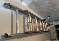 Top and side views of the 11 ft Werner aluminum extension ladder hanging horizontally with stabilizer bars attached, showing condition and features.